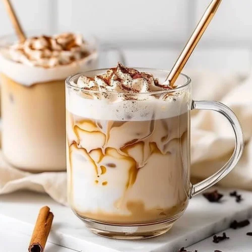 Iced honey cinnamon latte served in a glass with cinnamon stick and honey drizzle