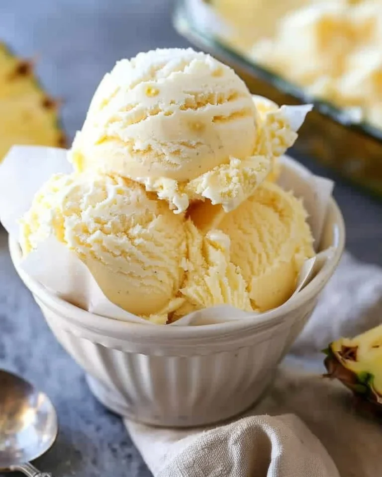Creamy homemade pineapple ice cream served in a bowl with fresh pineapple slices